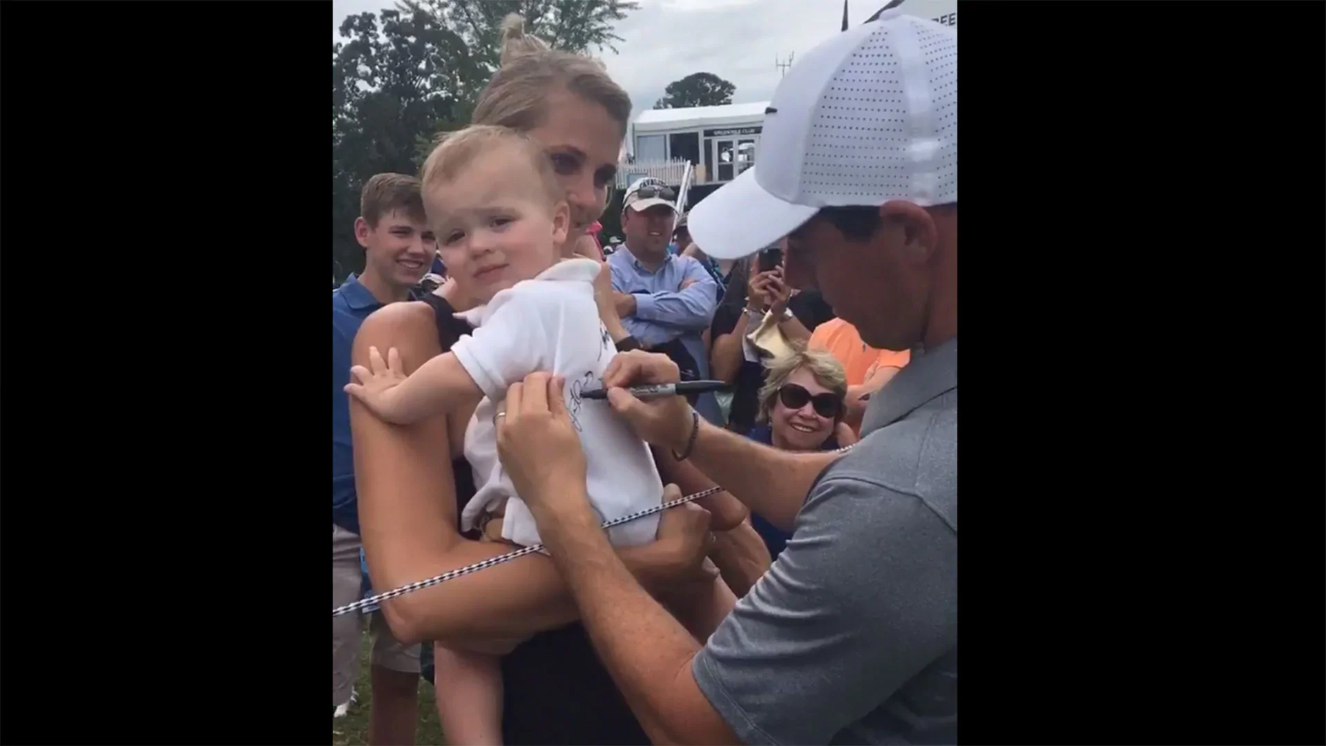 McIlroy autographs a baby at Quail Hollow